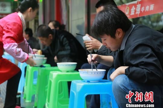 10月31日早，蘭州市永昌路一家牛肉面館門庭若市，20多平米的面館坐得滿滿當當，面館門外，顧客們有蹲著吃的，也有放個小板凳擱著吃的，取面口排成10余米的長隊。 劉玉桃 攝