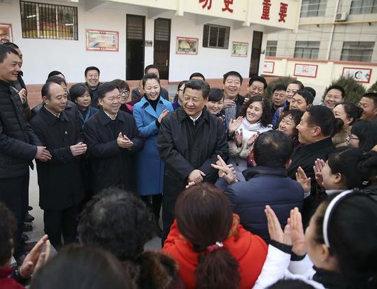 2015年2月14日上午,習近平在延安市楊家嶺福州希望小學視察后,與聞訊趕來的附近群眾親切交流并向大家拜年。 新華社記者 蘭紅光 攝