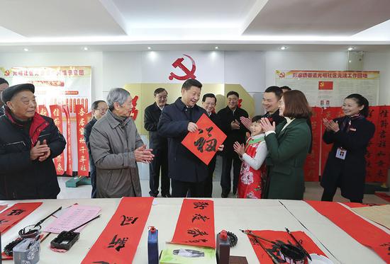 2016年2月3日,習近平在南昌市東湖區彭家橋街道光明社區書畫室,接過一位小朋友現場書寫的 “福”字,祝大家都幸福。新華社記者 蘭紅光 攝