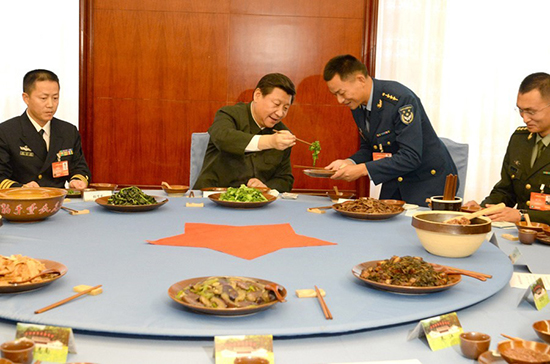 習(xí)近平與官兵吃“紅軍飯”，為官兵夾菜。據(jù)中國(guó)軍網(wǎng)/軍報(bào)記者